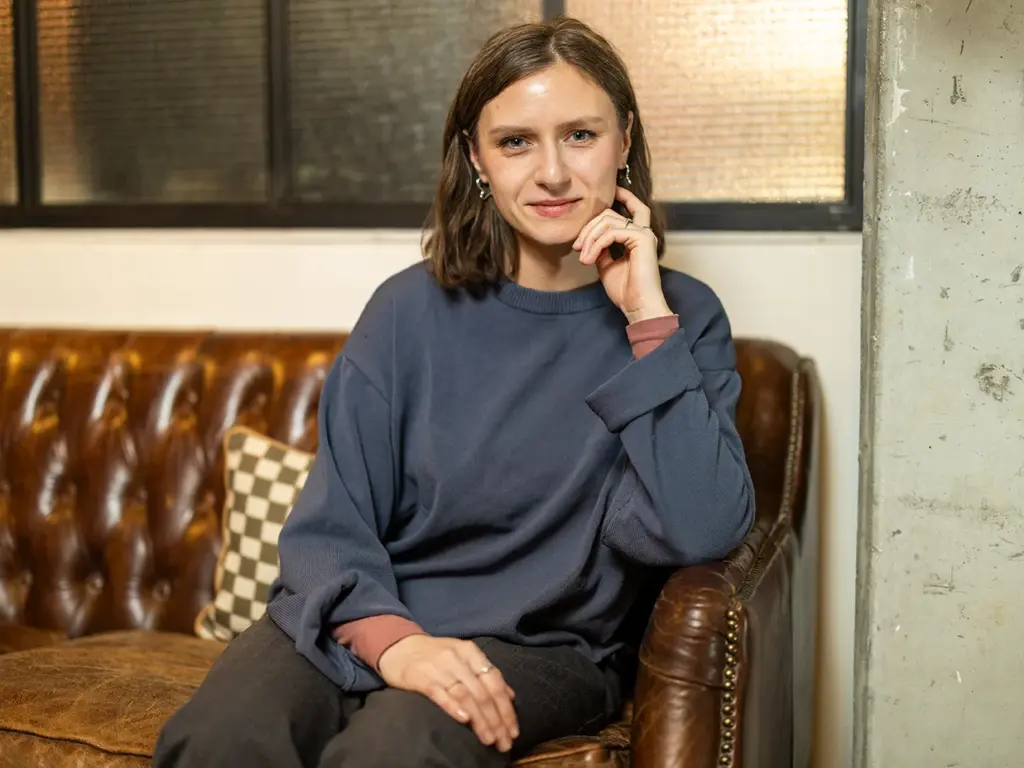 Mitarbeiterin auf einer Couch sitzend